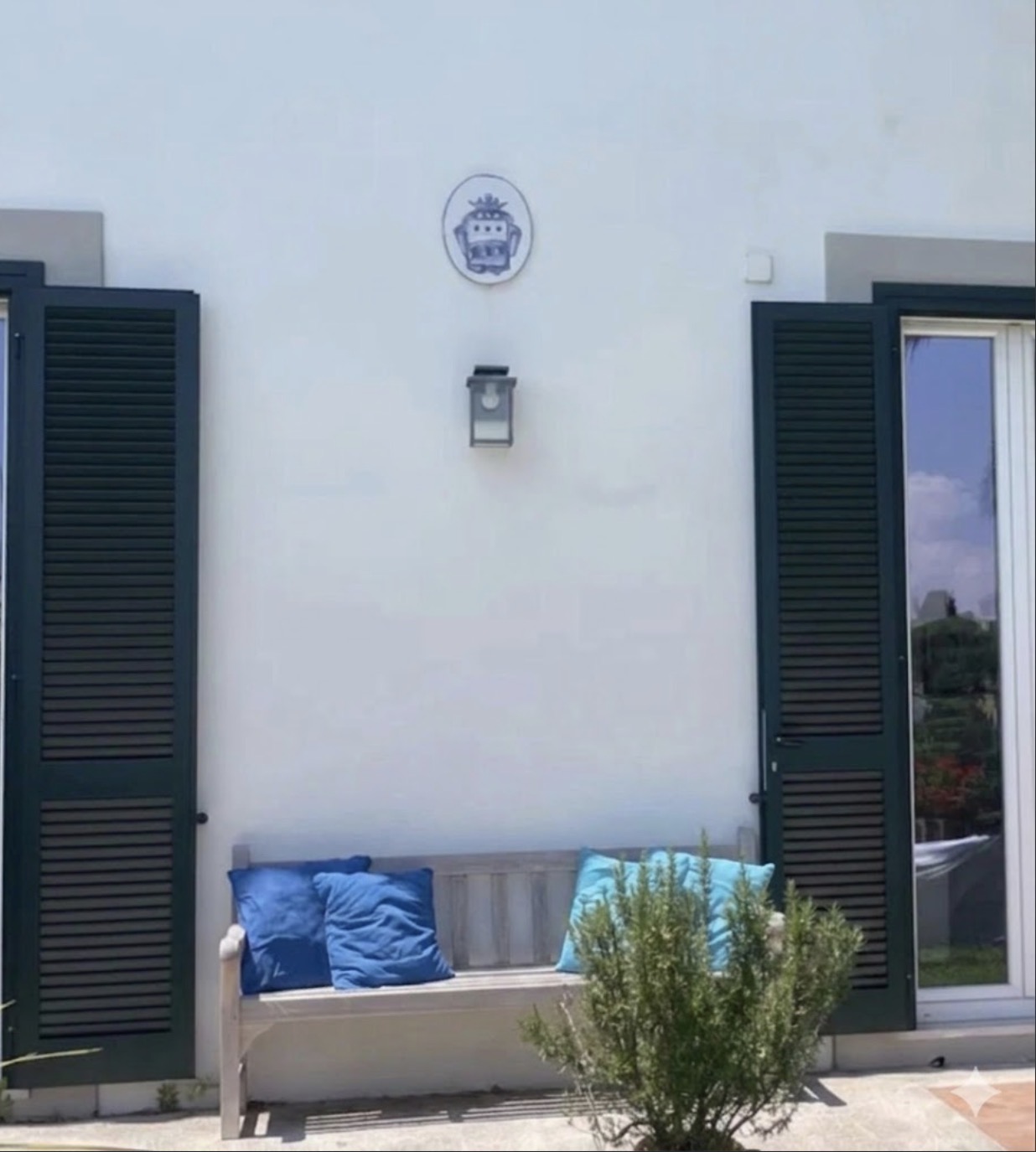 Panca con cuscini azzurri sulla facciata della villa