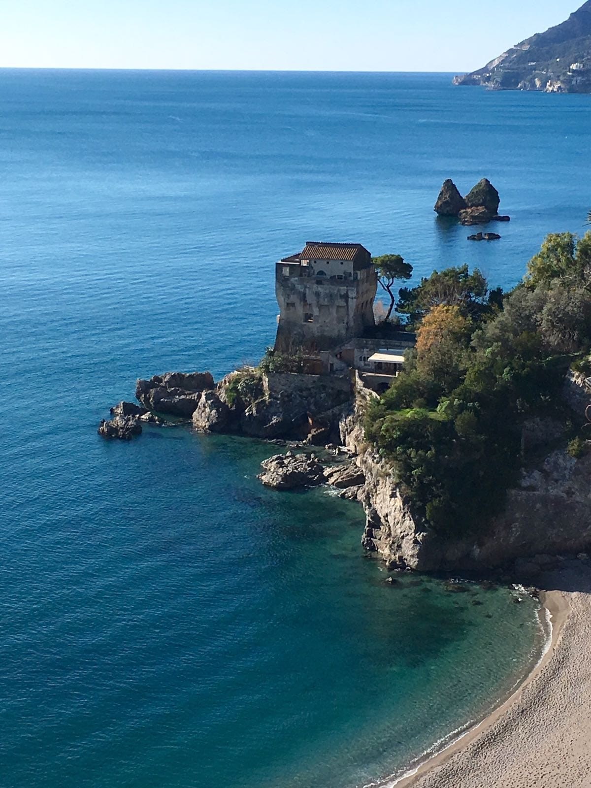 Veduta della costa con torre sul mare e scogli