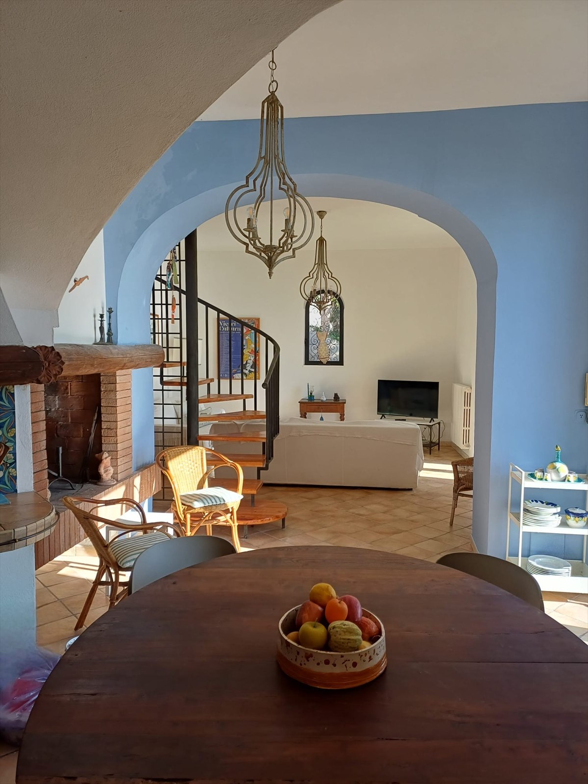 Zona pranzo con arco azzurro e vista sul soggiorno