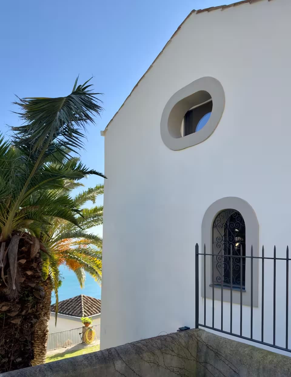 Facciata bianca di Villa San Vito con palme